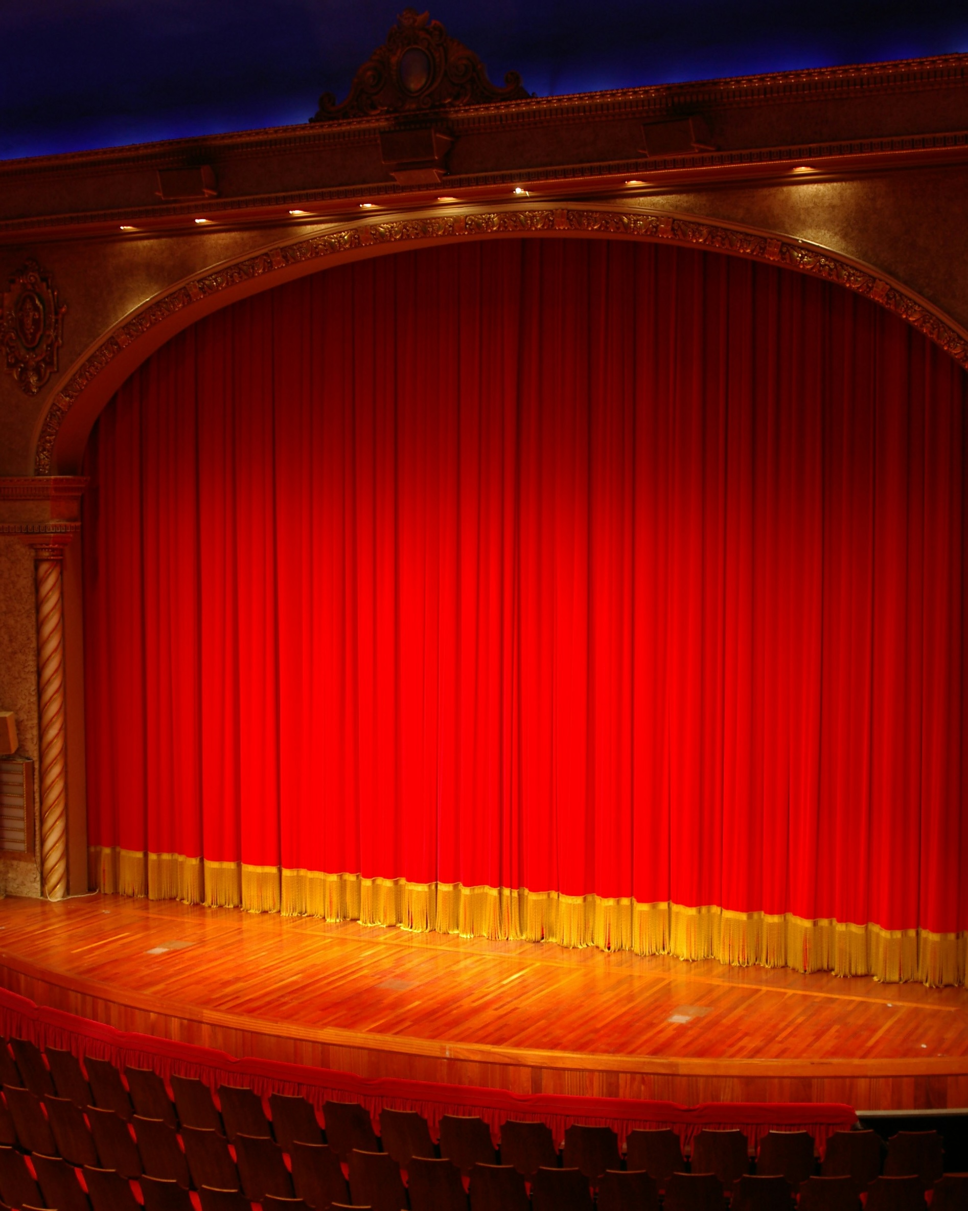 Red theater curtains framing a stage.